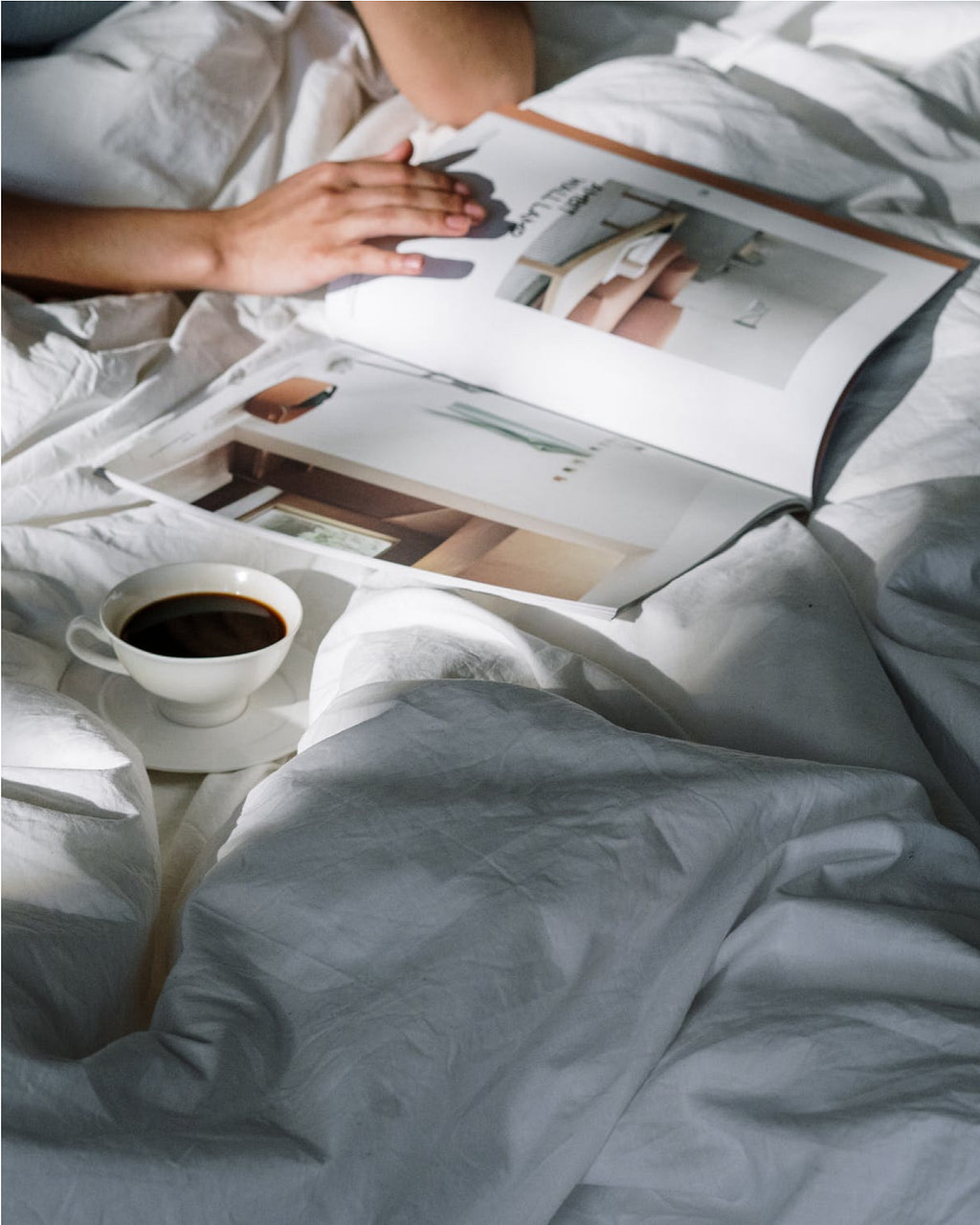 Person liest gemütlich ein Buch im Bett