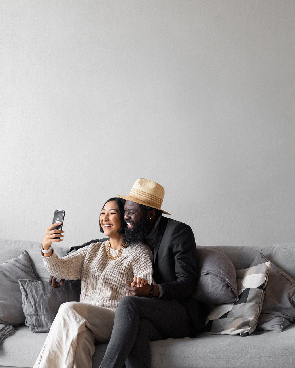 Paar sitzen auf Couch - die RAS Concierge App ermöglicht ein sorgenfreies Leben