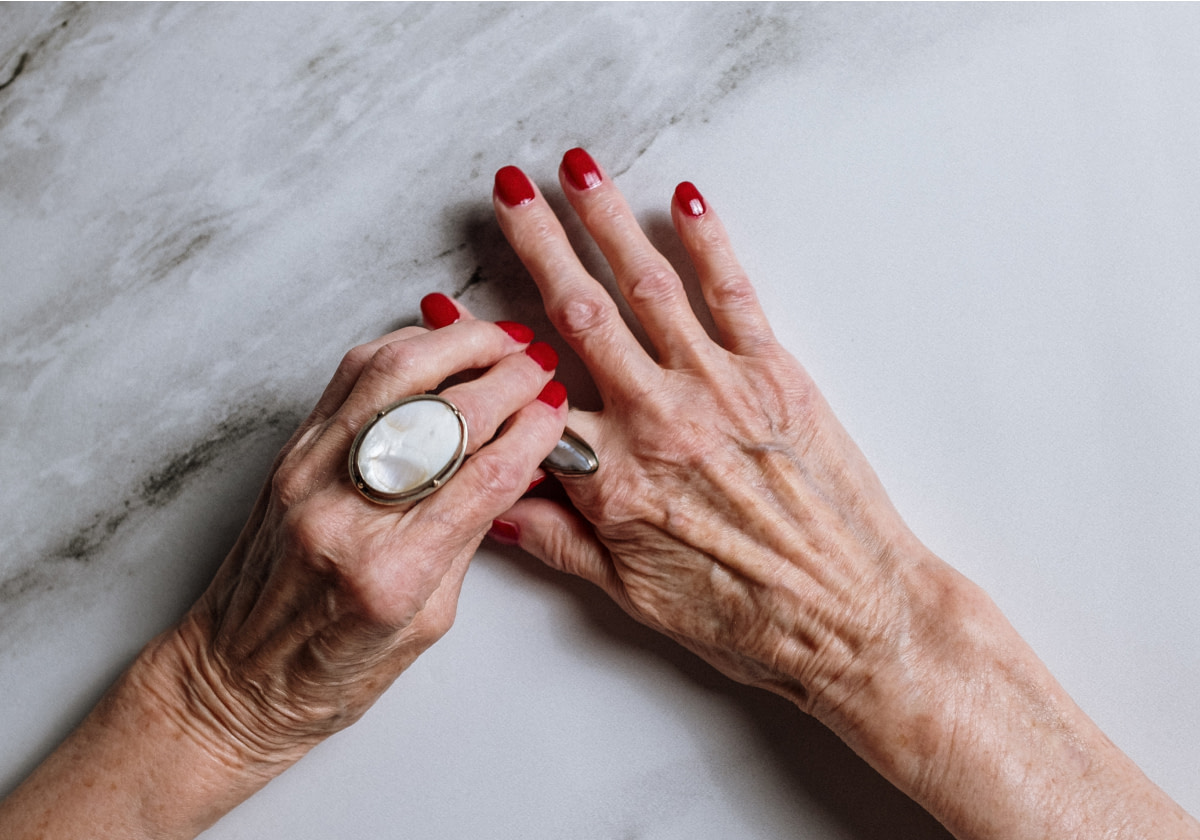 Hände einer älteren Dame mit roten Fingernägeln - RAS Quartier Services ist Spezialist für Quartiere für altersgerechtes Wohnen