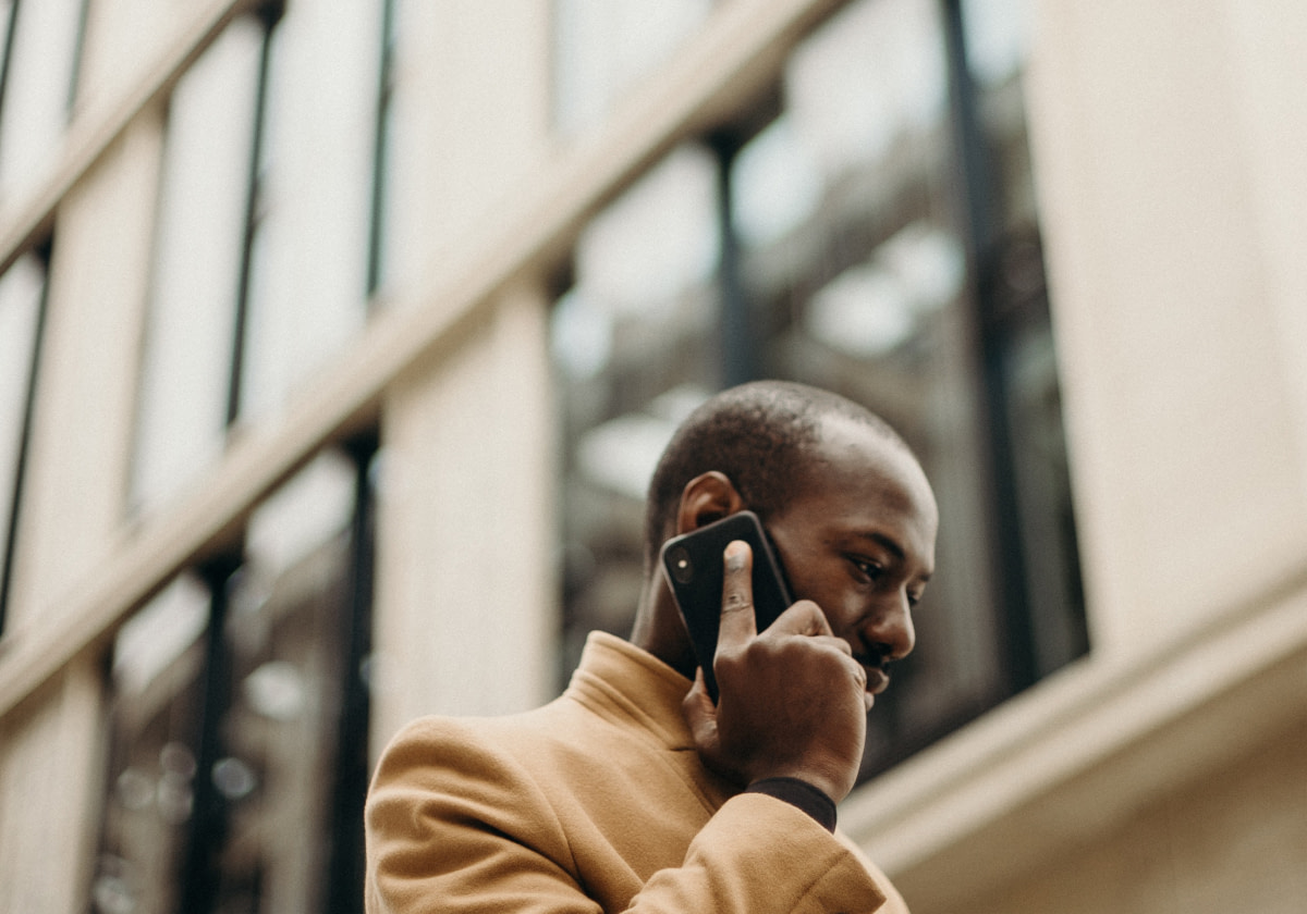 Mann telefoniert vor Gebäude - RAS Office Management sorgt für reibungslose Kommunikation
