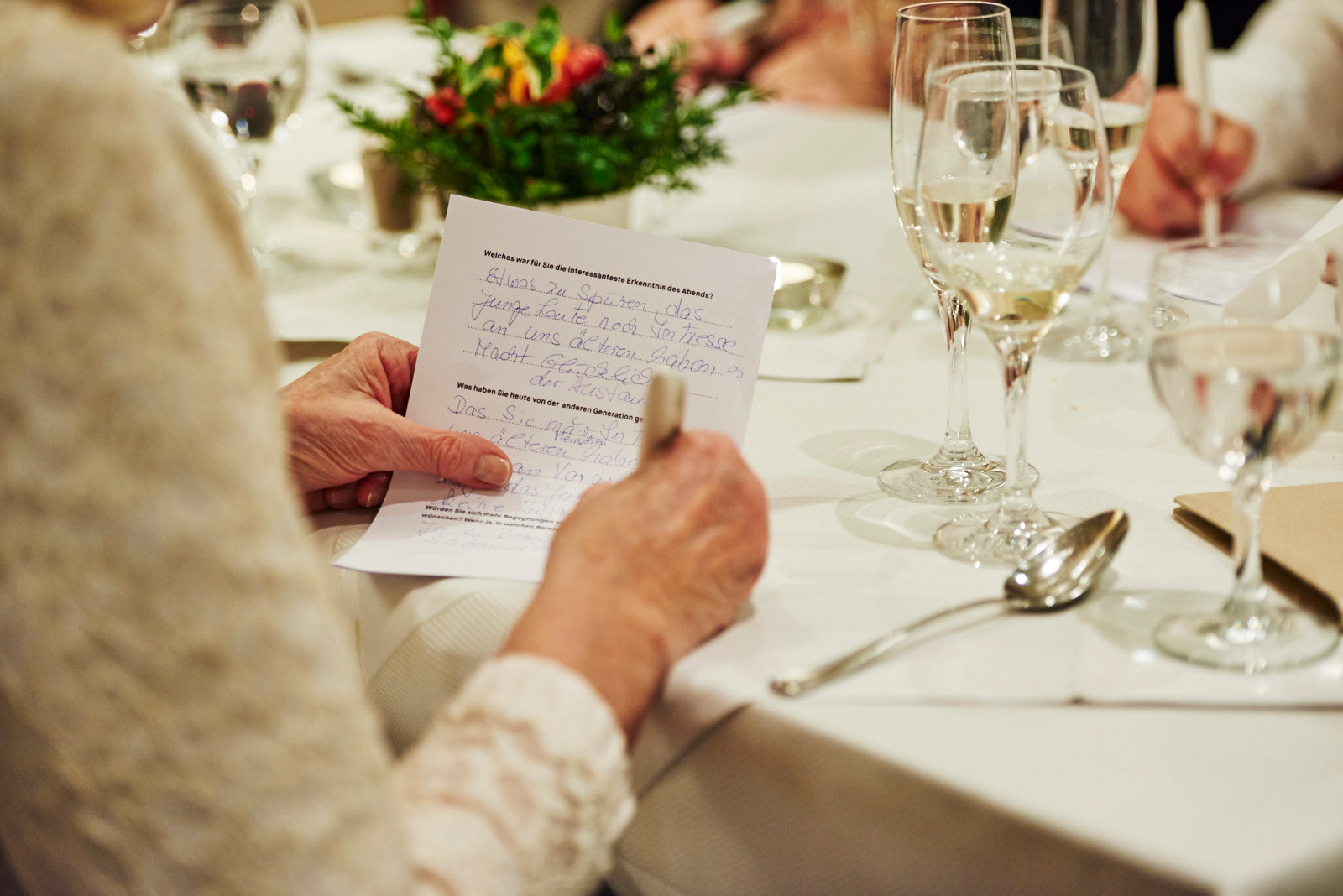 Seniorin füllt Feedback-Bogen für Generationen Dinner aus