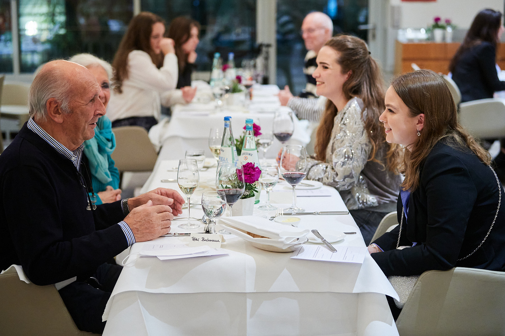Gäste unterschiedlichen Alters sitzen am Tisch beim Tertianum Generationen-Dinner