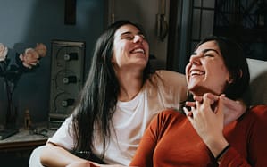 2 Frauen sitzen unbekümmert auf Sofa, dank RAS Concierge Service