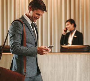 Geschäftsmann verwendet den digitalen Concierge der RAS App auf seinem Mobiltelefon.