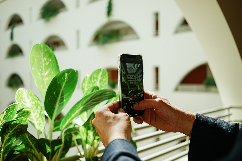 Person macht Handy-Foto des Attrium der Tertianum Premium Residence Berlin
