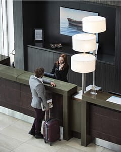 Mann beim Check-in am Concierge Desk von RAS Reception Services
