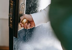 Person öffnet Tür - RAS Reception Services bewahrt die Welt der Sicherheit