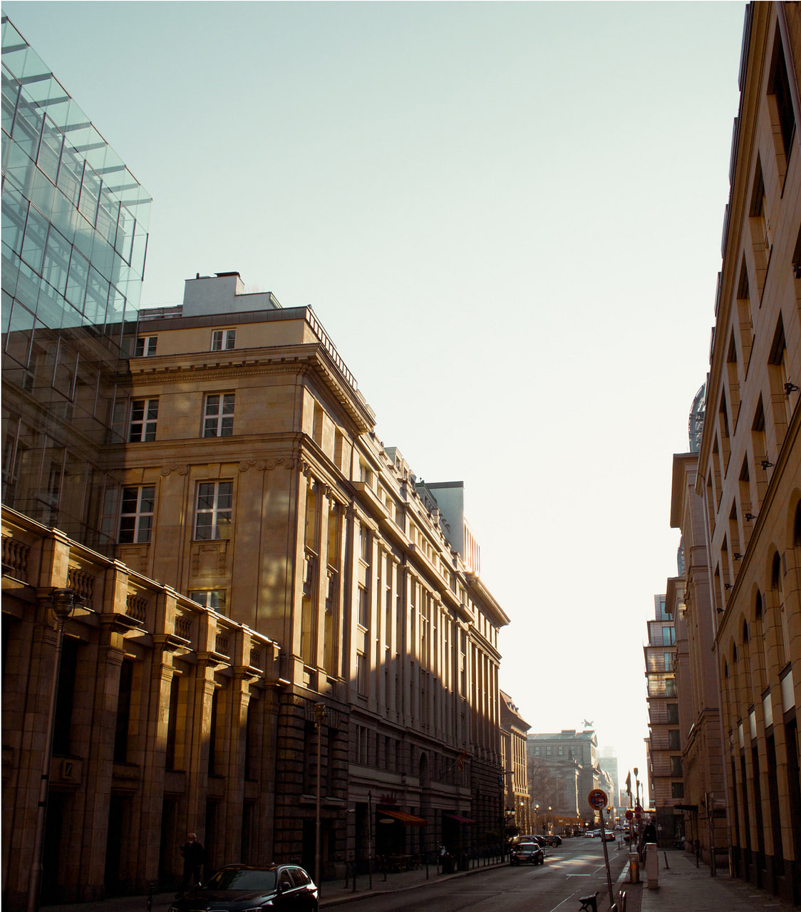 Straßenzug mit Gebäuden mit historischen Stein- und modernen Glasfassaden, die von RAS Quartiers Concierges betreut werden