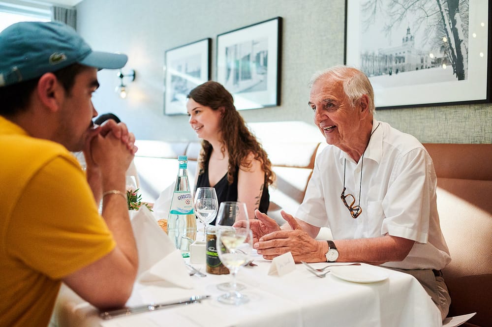 Junger Student lauscht den Geschichten eines Seniors beim Generationen Dinner