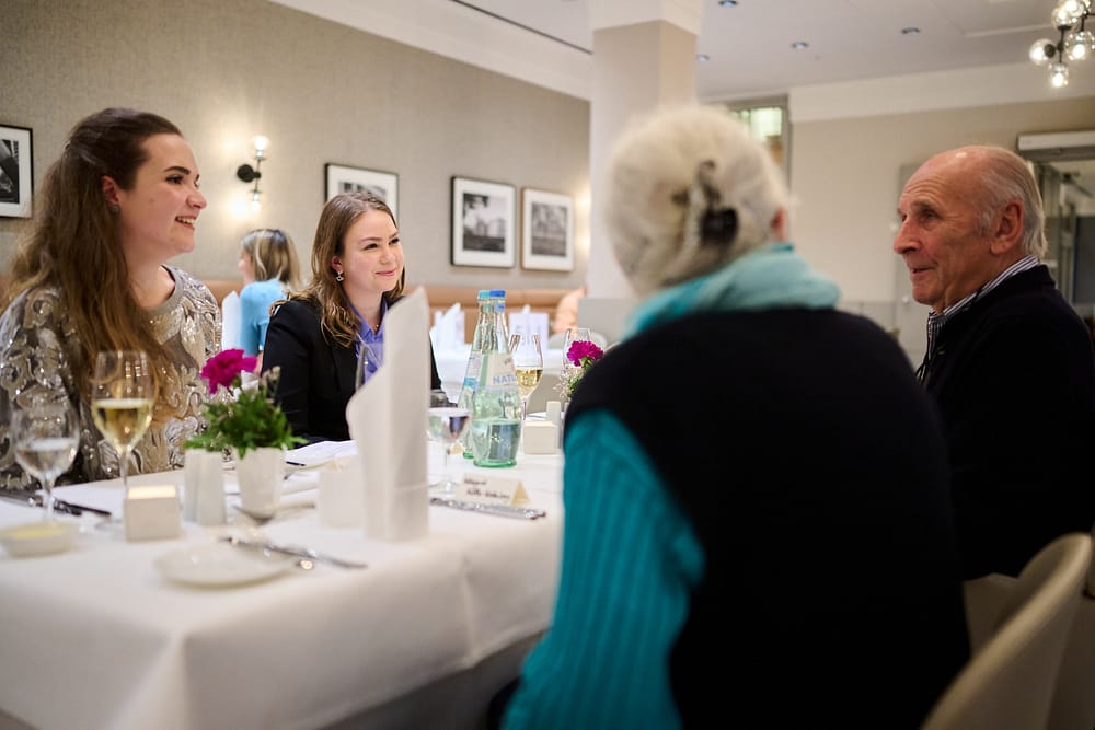 Gäste unterschiedlichen Alters sitzen am Tisch beim Tertianum Generationen-Dinner