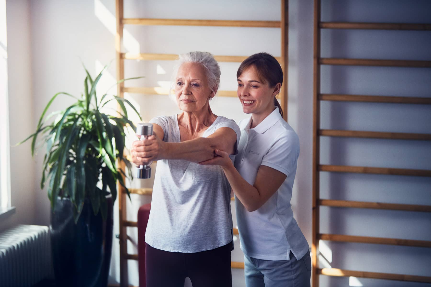 Eine Seniorin mit einer Pflegerin beim Sport in der Luxus Seniorenresidenz Tertianum