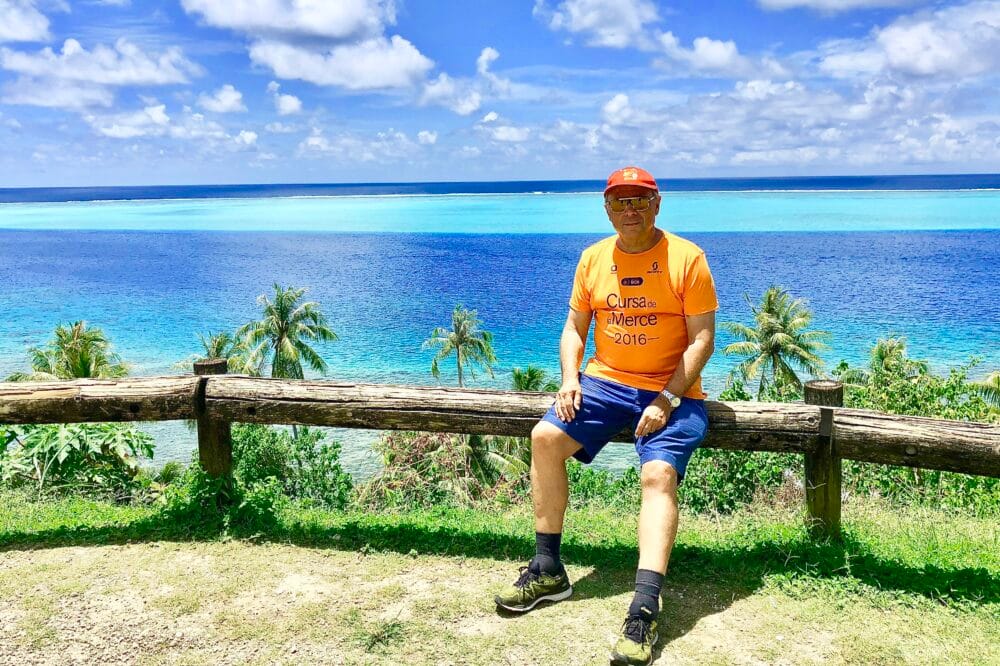 Peter Schiffer auf Huahine, im Hintergrund Palmen, blaues Meer und der Himmel mit kleinen Wolken.