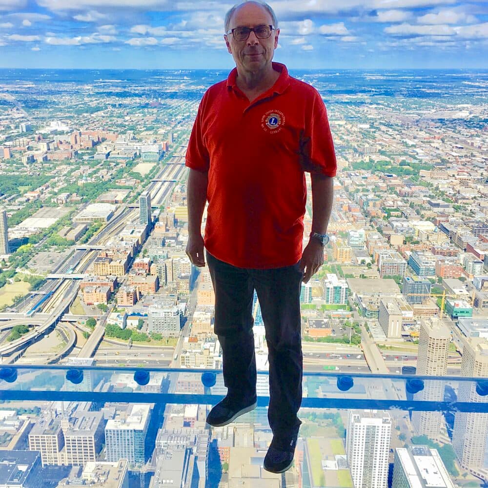 Peter Schiffer steht auf eine Glasboden auf dem Willis Tower in Chicago