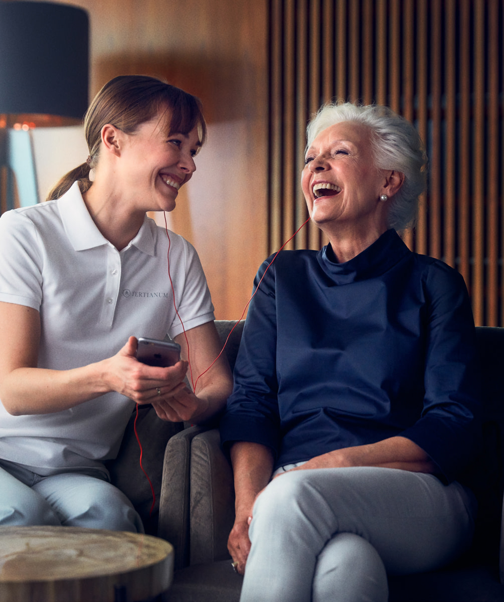 Freudige Seniorin zusammen mit einer Pflegerin