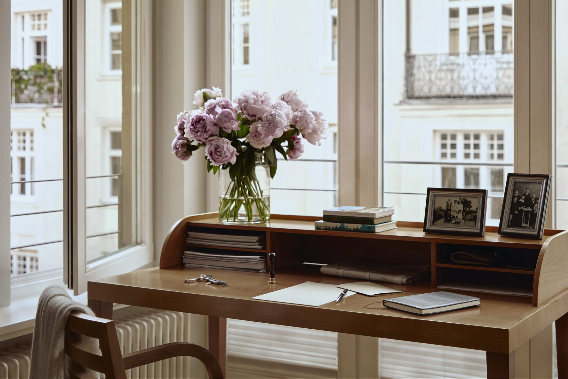 Schreibtisch am Fenster mit frischen Blumen