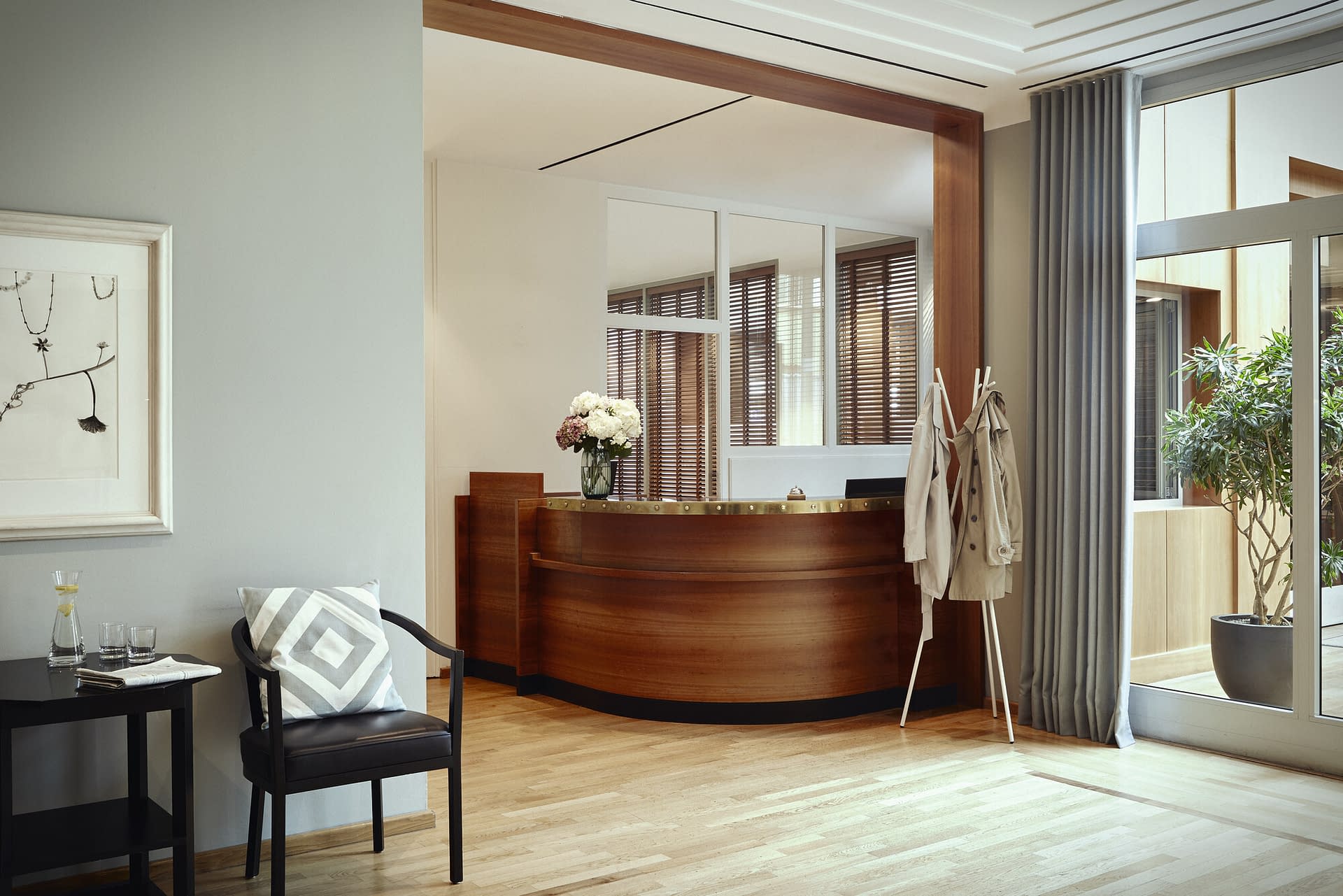 Die Rezeption mit Blumen, Sitzmöglichkeiten und einem großen Fenster im Seniorenhaus Tertianum