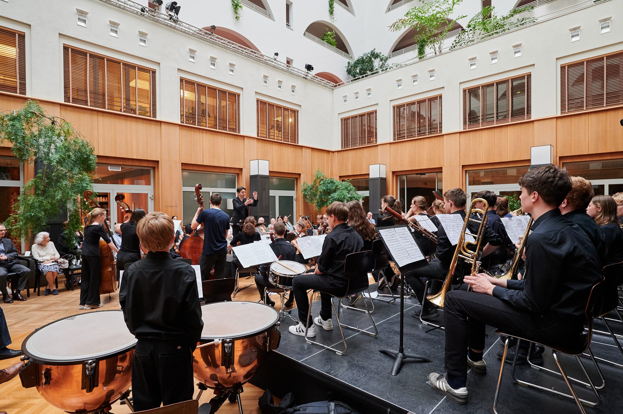 Ein Orchester von der Seite, die jungen Musiker*innen schauen konzentriert zum Dirigenten.