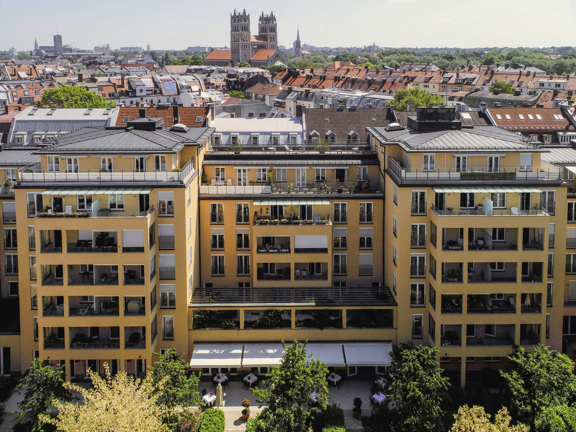 Eine Luftaufnahme der Außenfassade der Tertianum Seniorenresidenz Bayern mit Blick über München.
