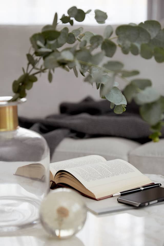 Schön dekorierter Tisch mit aufgeklapptem Buch und einer Vase