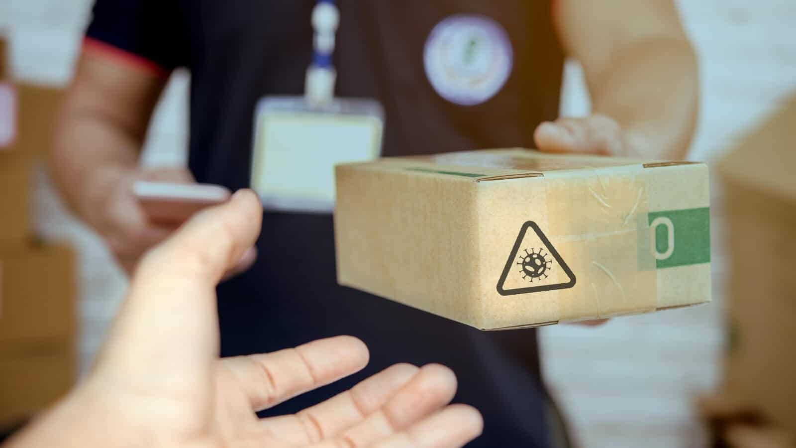 Paket mit Corona-Warnsymbol wird übergeben