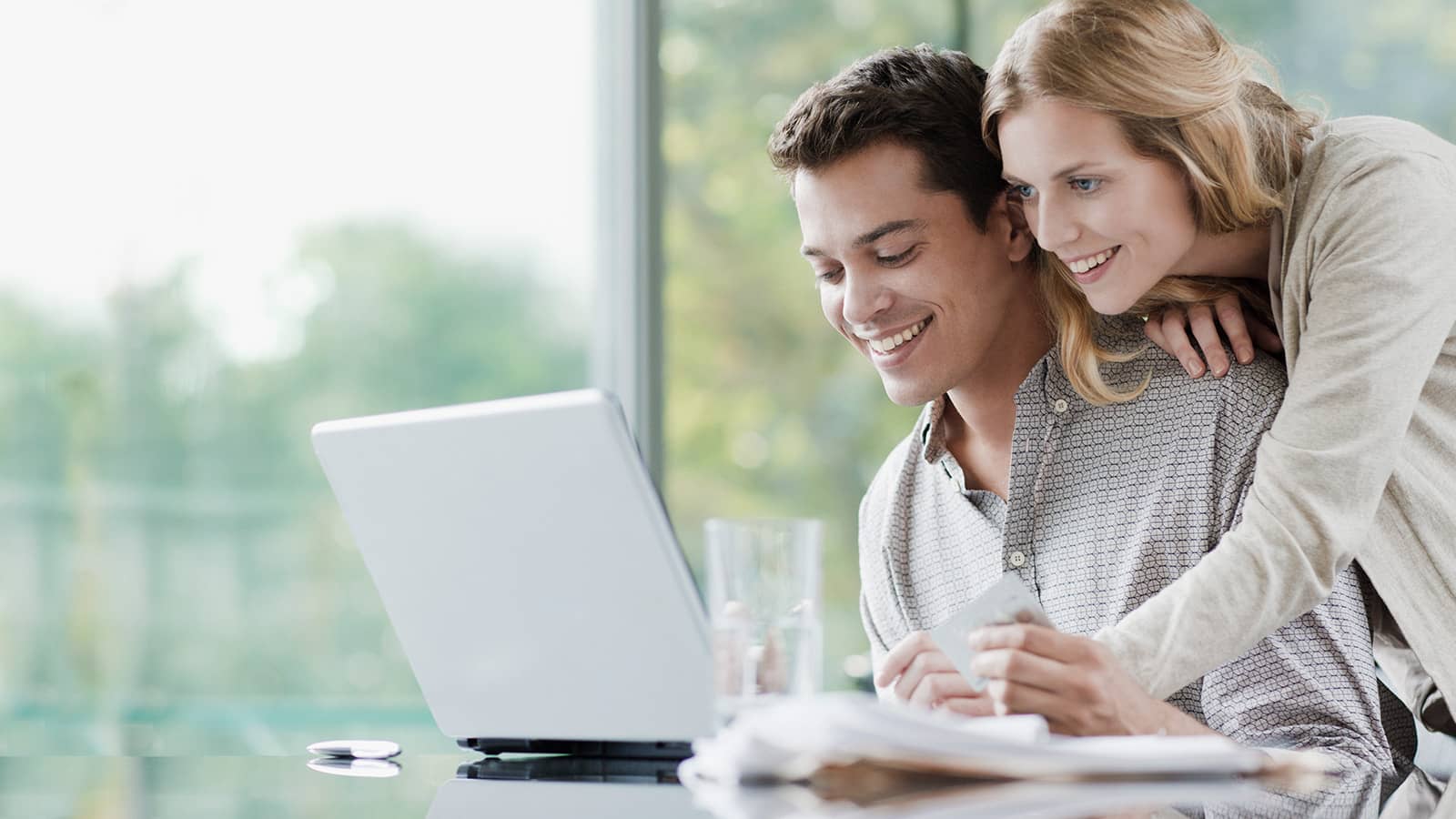 Junges Paar schaut auf Laptop und ist zufrieden mit dem easyCredit-Ratenkauf