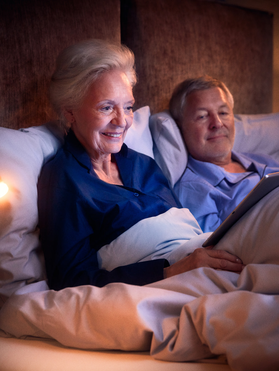Ein älteres Ehepaar im Bett ihrer Wohnung in der Tertianum Residenz