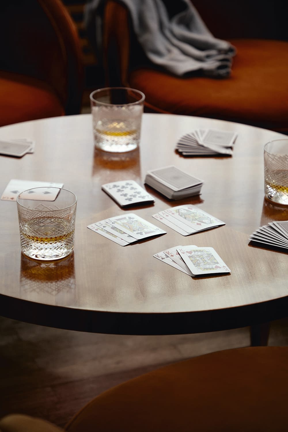 Ein Kartenspiel auf einem hölzernen Tisch mit Getränken in der Tertianum Senioreneinrichtung.