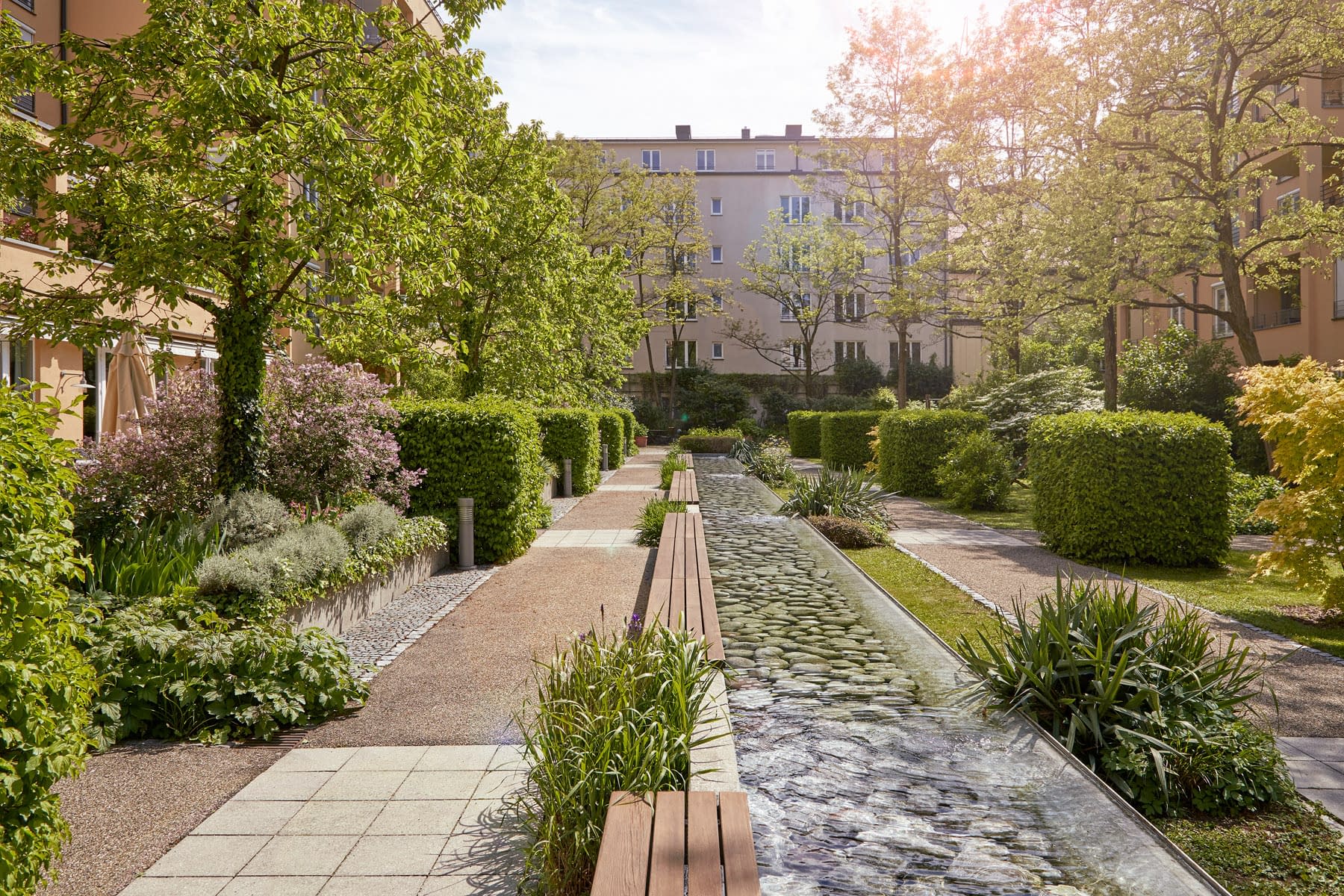 Begrünter Innenhof mit Steinweg im Altersruhesitz Tertianum München