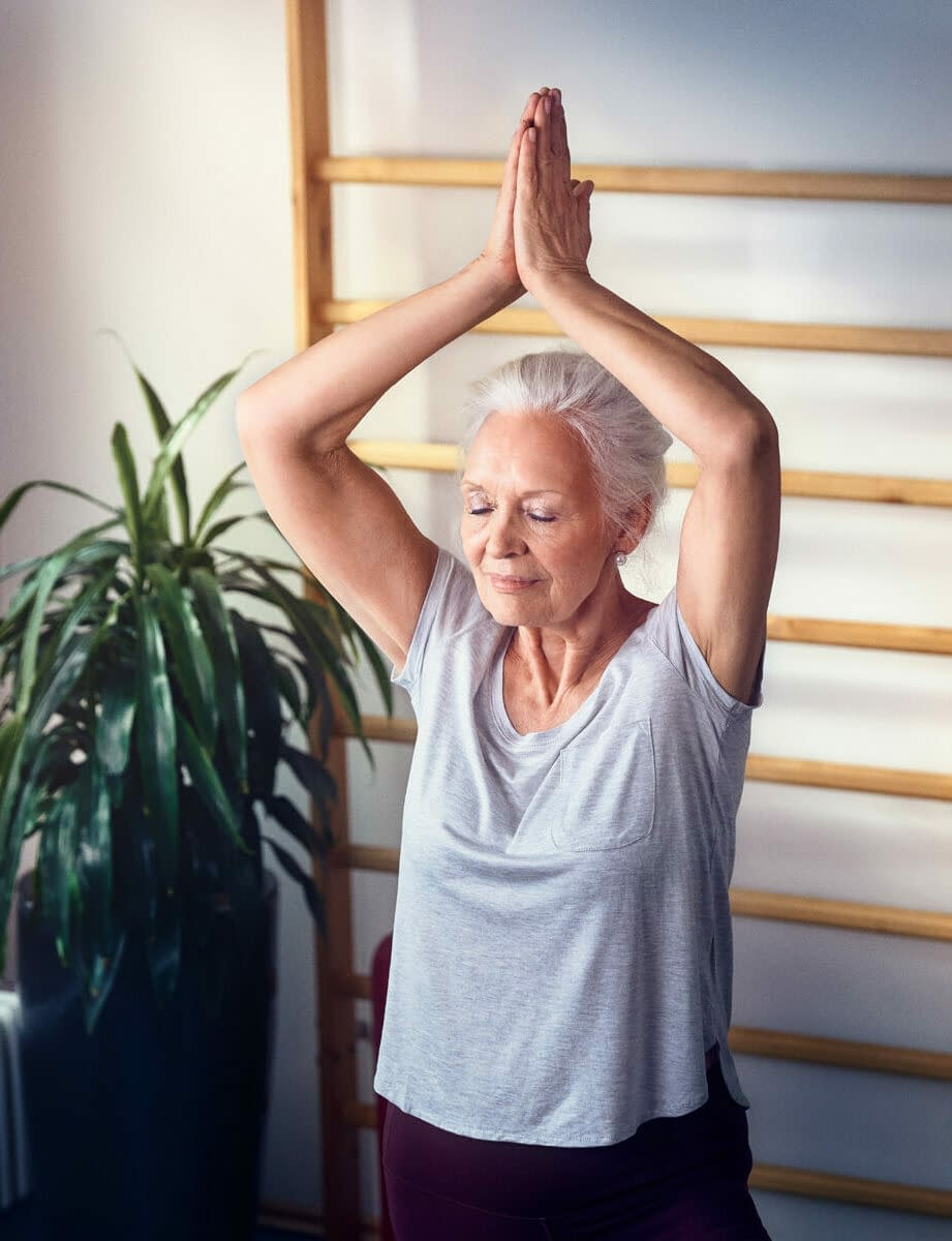 Eine Senioren macht Yoga in den Fitnessraum unserer Tertianum Altersresidenz
