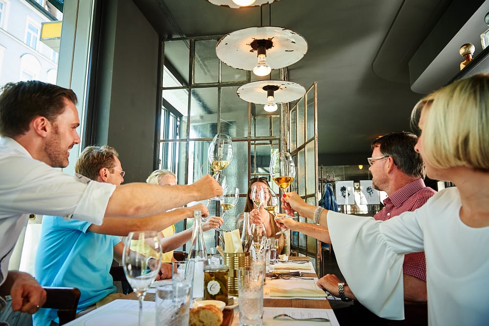 Gruppe von Gästen genießen einen genussvollen Abend voller modern französischer Küche in der Brasserie Colette Tim Raue