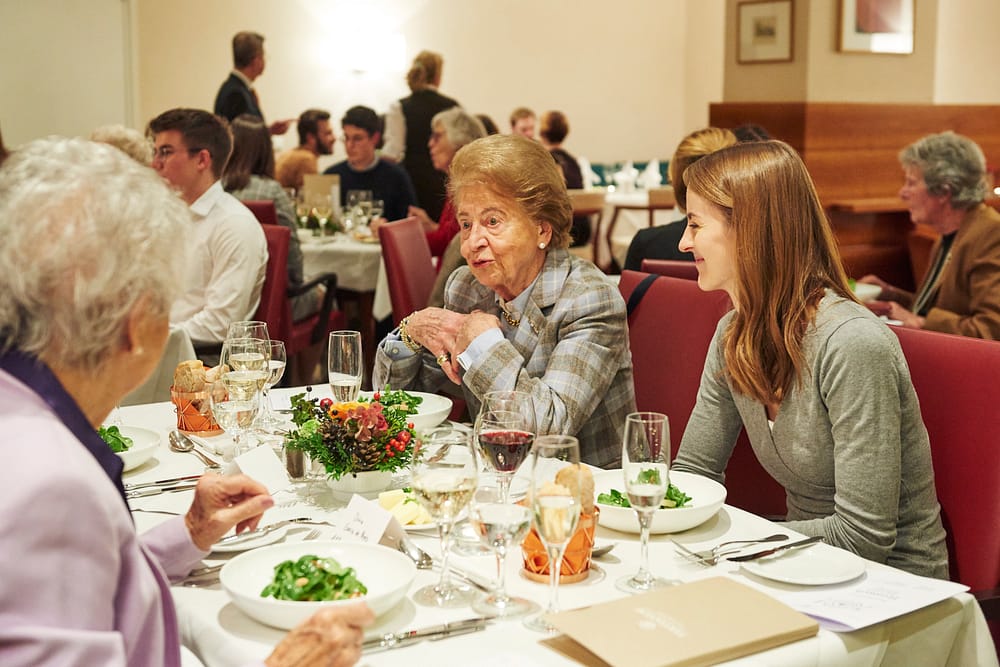Studentin unterhält sich mit zwei Seniorinnen beim Generationen Dinner
