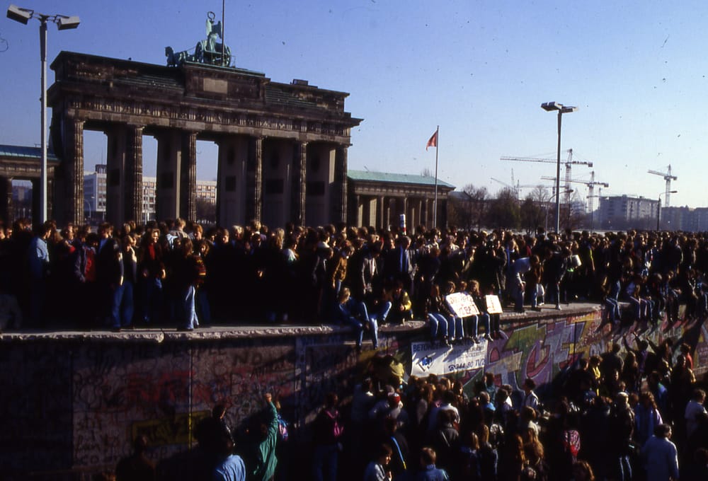 Menschen auf Berliner Mauer vor dem Brandenburger Tor