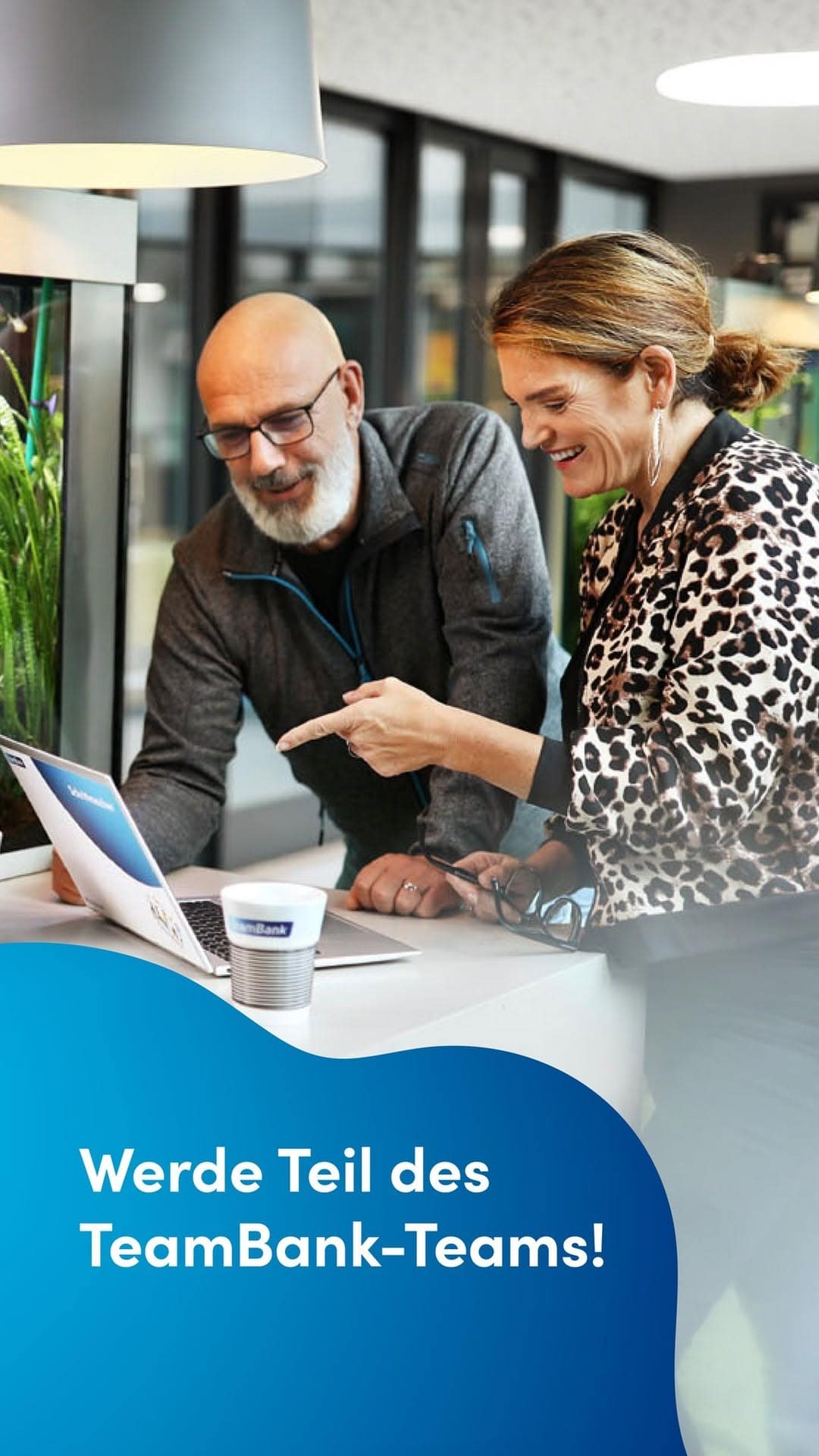 Zwei TeamBanker, eine Frau und ein Mann schauen auf einen Laptop. Der Text auf dem Bild heißt: Werde Teil des TeamBank-Teams!