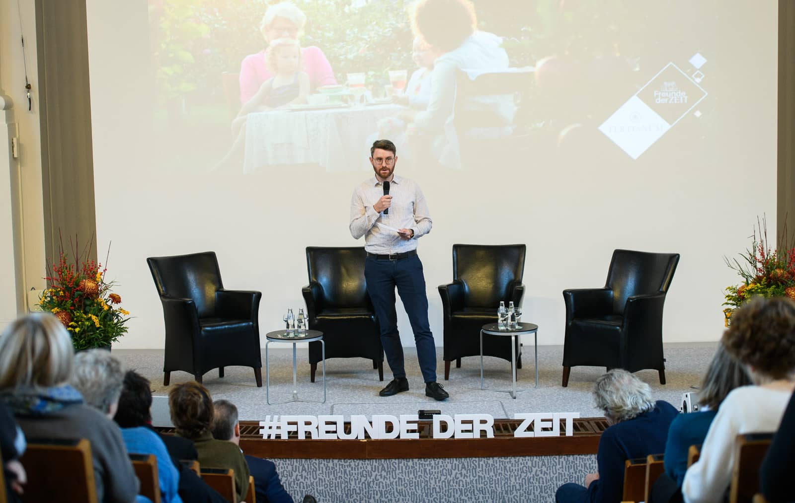 Moderator bei Veranstaltung spricht vor Publikum