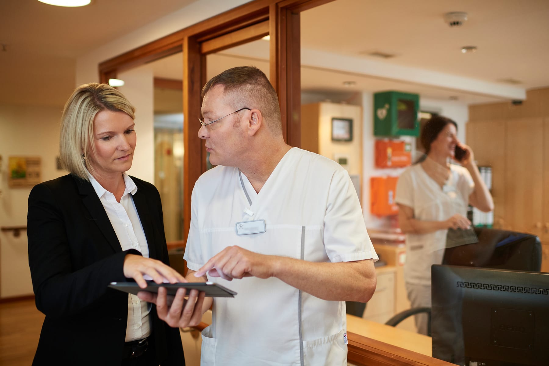 Digitalisierung in der Tertianum Premium Group - Mitarbeiter in der Pflege besprechen Fall am Tablet