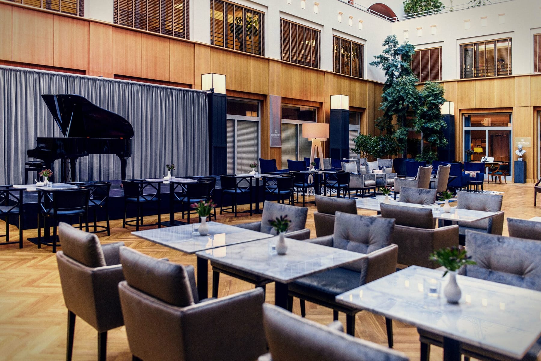 Launch-Bereich mit Flügel im Atrium der Tertianum Seniorenresidenz Berlin