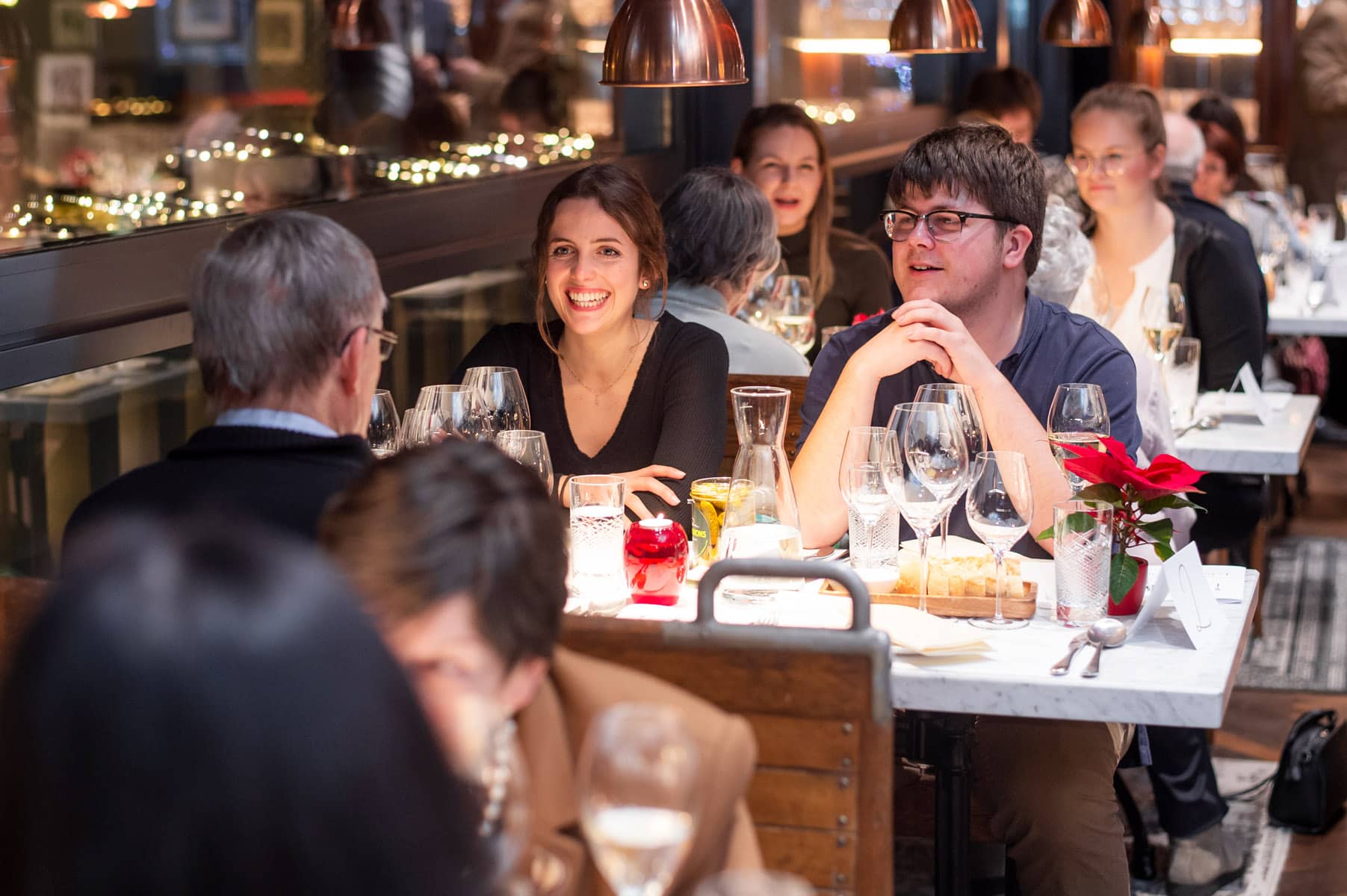 Studenten unterhalten sich mit Senioren bei Tertianum Generationen Dinner