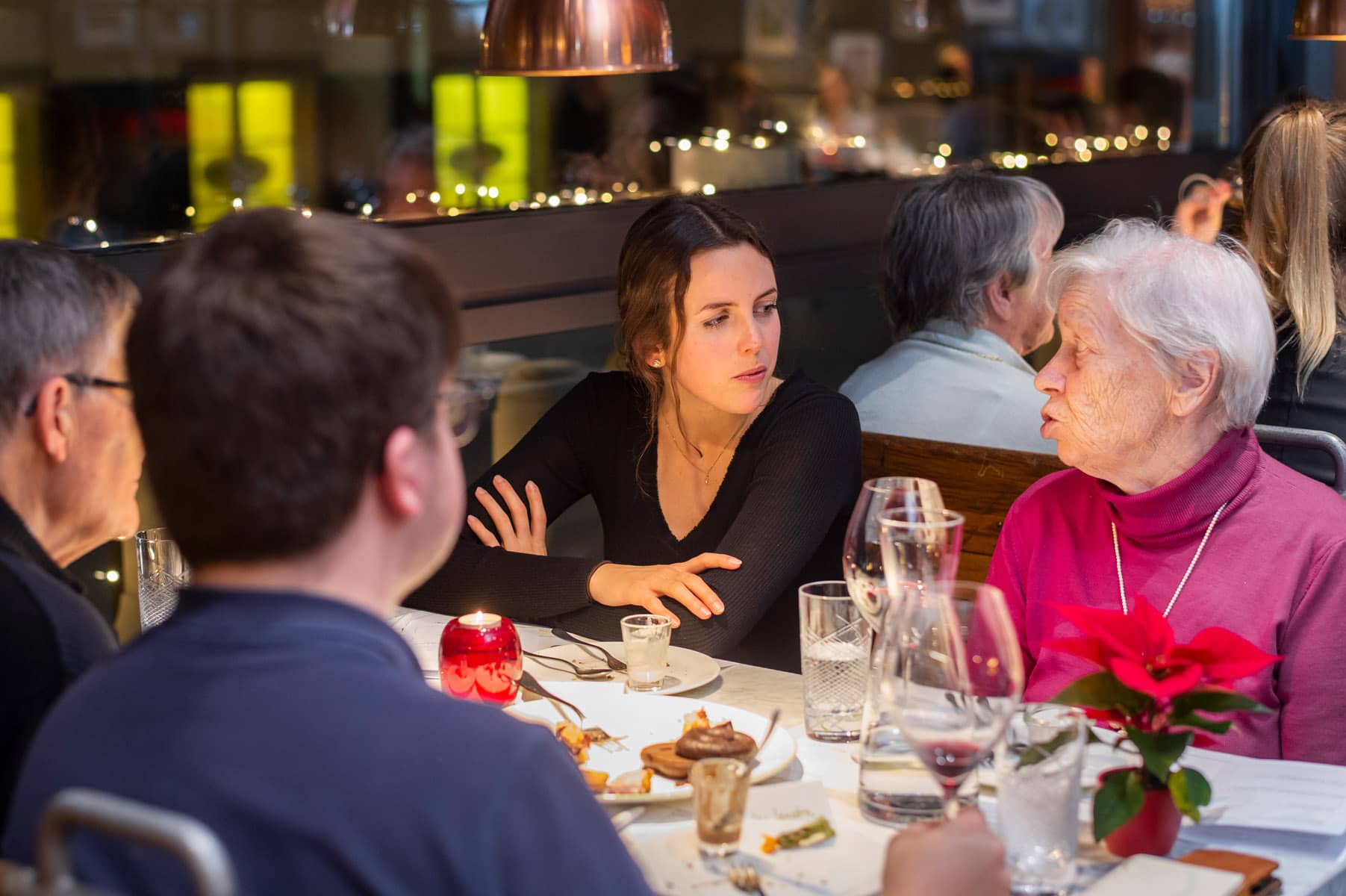 Seniorin spricht mit Sitznachbarin bei Tertianum Generationen Dinner