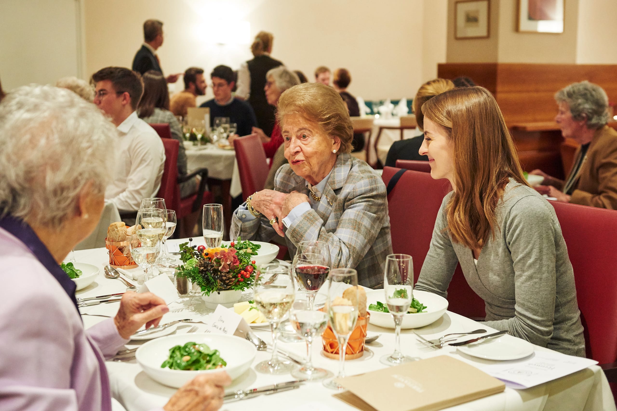 Studentin unterhält sich mit zwei Seniorinnen beim Generationen Dinner