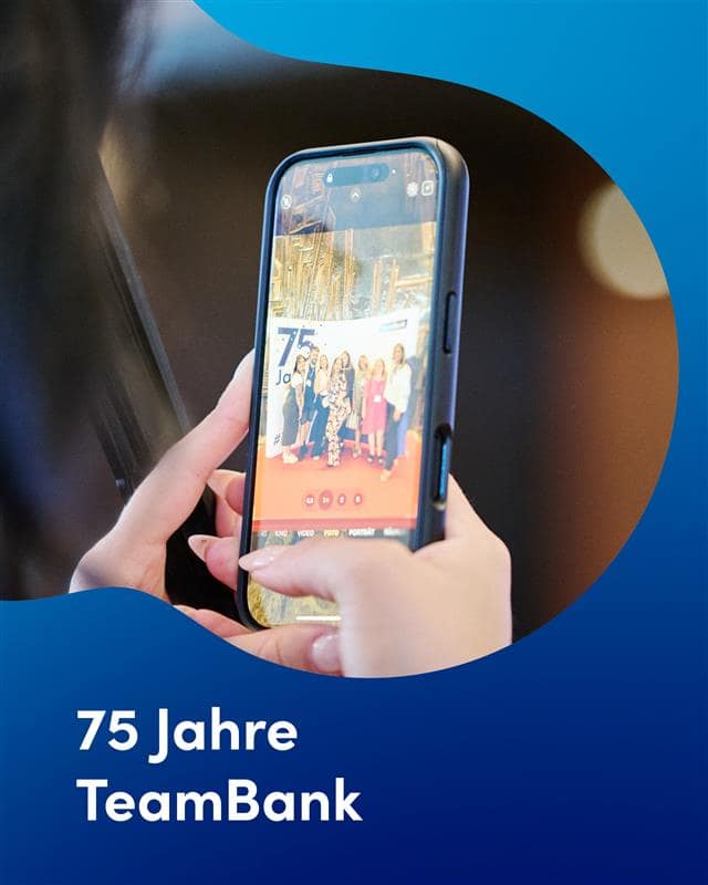 Close-Up von einer Person, die ein Smartphone hält. Sie nimmt gerade ein Foto von einer Gruppe Mitarbeitenden vor einer Fotowand auf. Die Schrift über dem Bild lautet: 75 Jahre TeamBank